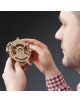 Човек в червено-бяла карирана риза държи 3D дървен пъзел Ugears - Календар, 24 части - сложен дървен пъзел с номерирани пръстени - на тъмен фон.-7-thumb