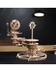 3D дървен пъзел Ugears - Tellurion Слънце, Земя, Луна, 249 части е механичен модел с колела, слънце с лъчи и глобус на маса. За него се виждат замъглена лампа и тъмен фон.-5-thumb