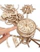 Една ръка сочи към 3D дървен пъзел Ugears - Tellurion Слънце, Земя, Луна (249 части), с преплетени зъбни колела, зодиакални знаци, съзвездия и декоративни гравюри. Сложният модел е изработен от лазерно изрязани дървени части.-3-thumb