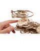 Една ръка докосва 3D дървен пъзел Ugears - Tellurion Слънце, Земя, Луна (249 части), детайлен дървен модел, изрязан с лазер, с преплетени зъбни колела и кръгла горна част, наподобяваща механичен телурион.-4-thumb