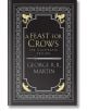 Корицата на "Пир за врани": Илюстрованото издание представя богато украсени сребърни и златни мотиви с мечове, врани и дракони на черен фон.-1-thumb