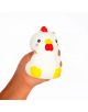 Една ръка държи Антистрес фигурка Legami - кокошка, бяла гумена играчка с жълти крачета, червен гребен и китка и розови бузки - идеална за играчка срещу стрес - на обикновен бял фон.-2-thumb