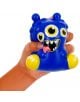 Една ръка стиска Антистрес фигурка Легами - Чудовище, синьо-жълта играчка с четири очи, отворена уста със зъби и изплезен език, идеална за намаляване на стреса.-2-thumb
