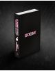 Черна книга с твърди корици, озаглавена "BOOM!" с дръзки розови букви, на чийто гръб се вижда CARE! Compassion & Curiosity и MATT DAMMAN в розово и бяло, лежи на тъмен фон - напомняйки за корици като Doomsday Scenario (Dungeon Crawler Carl, Book 2).-3-thumb