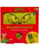 Празничната червена кутия съдържа Чорапи и маска за сън Fizz Creations - The Grinch: меки чорапи с лицето на Гринч и маска за сън с неговите жълти очи. Коледни графики и текст украсяват опаковката.-1-thumb
