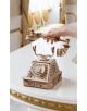 Ръката вдига слушалката на Дървен 3D модел на винтидж телефон за сглобяване EWA - богато украсен дървен аксесоар, изложен на бяла и златна маса, който придава винтидж чар на осветения от слънцето елегантен интериор.-11-thumb