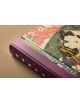 Близък план на книгата "Hokusai Shunga", включваща произведения на изкуството в японски стил с жена в традиционно облекло от епохата Едо на корицата и лилав гръбнак с бели надписи, изобразени върху кафява повърхност.-3-thumb
