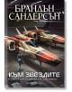 Във футуристичен хангар пилот се приближава до два елегантни червено-бели кораба. Корицата на "Към небето - книга 2: Към звездите - Обновено издание" има смел текст на кирилица, внушаващ научнофантастично усещане, вдъхновено от света на Брандън Сандерсън.-2-thumb