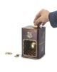 Ръката вкарва монета в кафявата Касичка ABYstyle Harry Potter - Golden Snitch с прозрачно прозорче, разкриващо Златен снич. Няколко монети лежат в близост до-идеален подарък за всеки фен на Хари Потър.-2-thumb
