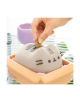Ръката поставя монета в Касичка Grupo Erik Pusheen The Cat, оформена като анимационния герой Pusheen, в бежова тава с пастелно розови акценти - възхитителен подарък за любителите и колекционерите на котки.-3-thumb