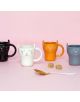 Комплект чаши за кафе Balvi - Meow, 4 бр. включва черна, бяла, оранжева и сива керамична чаша с форма на котка върху розов фон, пред които има бяла и златна лъжичка и две кафяви захарни кубчета.-3-thumb