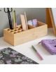 Дървен органайзер за бюро побира химикалки, ножици, линийка и гумички. Наблизо има тетрадка на цветя Miquelrius, зелена и розова химикалка, Комплект лепящи листчета Miquelrius Golden Jazmine, лилав текстуриран калъф с очила и част от клипборд.-5-thumb