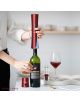 Човек използва Комплект за вино Cheer Moda Coffret Skyline, червен, за да отвори бутилка вино на бяла маса с чаша и чиния на заден план.-7-thumb
