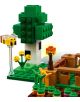 Сцена от LEGO със зелено дърво, кафява ограда, жълти цветя, малък оранжев фенер и пчела върху прозрачна поставка — всичко това е изградено от LEGO кубчета, вдъхновени от комплекта „Къщата на прасенцето“ от серията LEGO Minecraft.-5-thumb