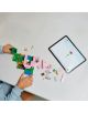 Някой сглобява яркия комплект „Къщата на прасенцето“ от LEGO Minecraft върху маса, като се ръководи от цифровите инструкции, които се виждат на таблета до него.-8-thumb