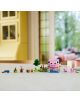 Комплектът „LEGO Minecraft Къщата на прасенцето“, включващ минифигурки, дървета и аксесоари, е изложен върху светла повърхност в светла стая с големи прозорци и жълта кухня на заден план.-10-thumb