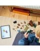 Едно дете седи на килимче и сглобява комплекта „LEGO Minecraft: Минна експедиция с броненосец“, като следва инструкциите на таблета. Наоколо са разпръснати LEGO елементи, малки фигурки и играчка от „Minecraft“.-7-thumb