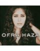 Жена с дълга, къдрава тъмна коса и светли очи гледа към камерата, облечена в тъмен топ. Удебелен текст в долната част гласи: "Ofra Haza - Ofra Haza (VINYL)", празнуваща етно-поп музика на тъмен фон.-thumb