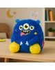 Плюшена играчка Legami - Чудовище: Син плюшен монстър с три очи, жълти крачета и усмихнато лице стои на дървена маса - идеален подарък за любим човек в уютна стая с леко размазан фон.-4-thumb