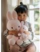 Малко дете с тъмна коса, облечено в риза на цветя, седи до прозореца и държи до гърдите си две плюшена играчка Miffy Terry - светлорозов заек, 23 см от Bon Ton Toys.-5-thumb