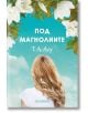 Корица на книгата Под магнолиите от Т. А. Лоу показва жена с дълга руса коса, погледната отзад, застанала под цветя на магнолия на фона на синьо небе. Предлага се в книжарница Orange.-2-thumb