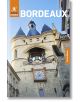 Корица на Rough Guides Bordeaux: Пътеводител с електронна книга, на която е показана историческата каменна порта с кули близнаци, голям часовник и камбана под синьо небе. Отстрани е поставен оранжев етикет "Безплатна електронна книга".-1-thumb