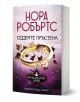 В българската книга "Прокълнатите булки, книга 3: Седемте пръстена" са изобразени два сватбени пръстена, малки цветя и бръшлянови листа върху лилава корица. Автор: Нора Робъртс.-1-thumb