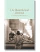 Корицата на книгата "Красиви и прокълнати" (Macmillan Collector's Library) представя жена в богато украсена рокля, която се взира в отражението си в огледало, осветено от светещи полилеи.-thumb