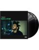 Обложка на албума The Weeknd - Kiss Land (2 VINYL), на която е изобразен сериозен портрет на изпълнителя с размазани градски светлини на заден план и две черни винилови плочи, които се виждат частично зад обложката.-thumb