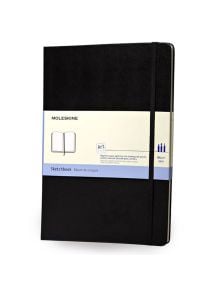 Черен скицник Moleskine с ластик, показан с хартиен калъф, в който е описано, че е художествен скицник със 165 страници, е показан изправен и затворен - предлага се в книжарница Orange.