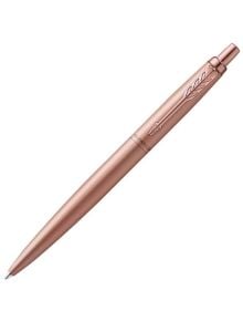 Химикалка Parker Royal Jotter XL Monochrome Pink Gold - Special Edition в розово злато с прибиращ се накрайник и декоративен клипс със стрелка, заснета на бял фон, налична в книжарница Orange.