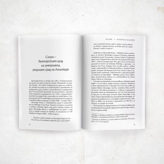 Отворена книга със заглавие "440 дни Ататюрк в България" лежи върху бяла повърхност и показва две страници с черен български текст с центрирано заглавие вляво; и на двете страници има абзаци без изображения или илюстрации.-4