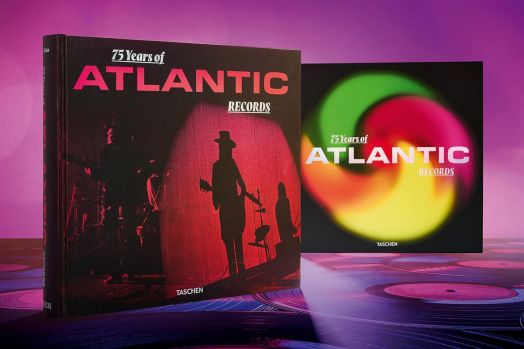 Снимка на 75 Years of Atlantic Records представя впечатляващата корица със силуети на музиканти и смел червен текст, показан до ярко изображение на тема винил - в чест на фотографското наследство на Atlantic Records.-3