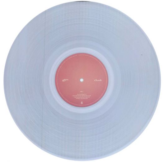 Прозрачна винилова плоча от Charli XCX - Charli (2 VINYL) с розов централен етикет върху бял фон. "charli" се появява в бял текст, а ритъмът на хиперпоп албума се вижда едва доловимо.-2