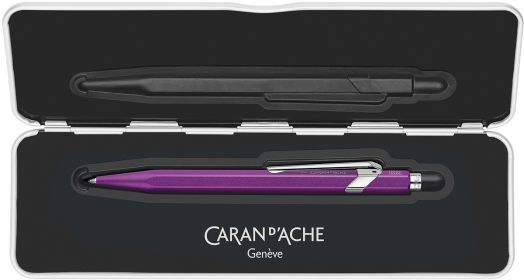 Лилавият Химикалка Caran D'Ache 849 със сребърен клипс е изложен в черен презентационен калъф от Книжарница Orange, с отпечатано логото на марката и Genève отвътре.-2