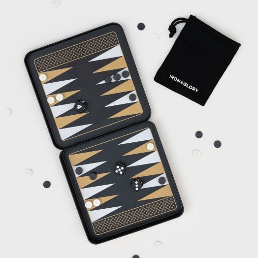 Игра Iron & Glory - Магнитна табла в черно и златно е отворена, показвайки пулове и зарчета, с разпръснати черни и бели чипове и черна торбичка с надпис IRON & GLORY до дъската.-2