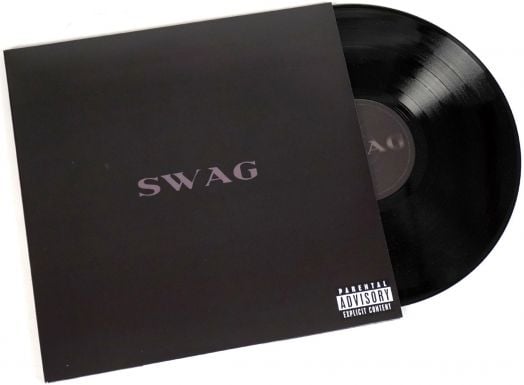 Черна винилова плоча наднича от матова черна обвивка с надпис "SWAG" в сиво, който препраща към албума Justin Bieber - Swag (2 VINYL). Препоръка към родителите: В долния десен ъгъл е поставен етикет с ясно съдържание.-1