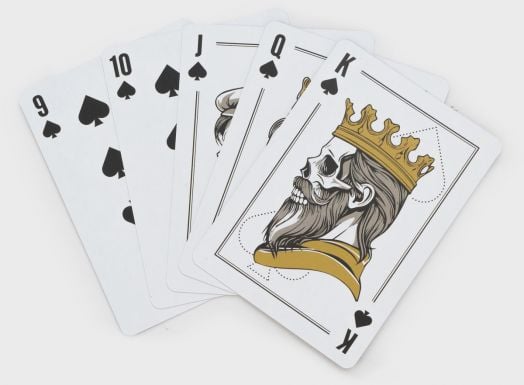 Петте карти за игра - 9, 10, вале, дама и крал на пика - са разпръснати със стилизирани лицеви карти и крал със златна корона. Карти за игра в дървена кутия Iron & Glory Big Deal е луксозен избор за всяка покер вечер.-6