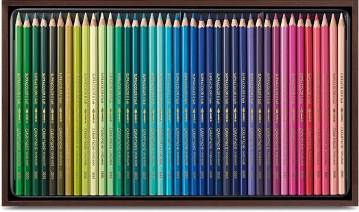 Кутия с Caran d'Ache Supracolor цветни моливи, подредени в редица, с градиент от зелено, синьо и лилаво до червено и розово в тъмнокафява правоъгълна кутия.-2