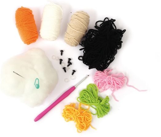 Разнообразни прежди, пълнеж, игла, розова кука за плетене на една кука и аксесоари от Комплект за плетене Амигуруми Graine Creative - Еднорог Сора са подредени върху бяла повърхност - идеална за изработване на амигуруми еднорог или други сладки творения.-4