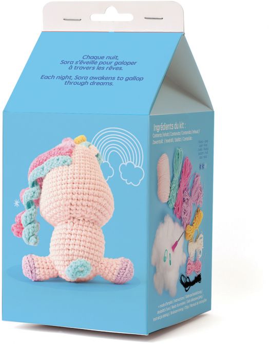 В синята кутия на комплекта "Комплект за плетене Амигуруми Graine Creative - Еднорог Сора" са изобразени плетен на една кука еднорог (изглед отзад), пастелна прежда, кука за плетене на една кука, облачен пълнеж, очи, текст на френски/английски език и илюс-3