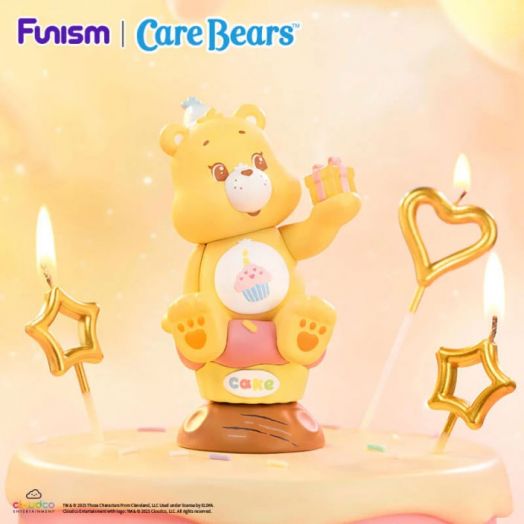 Жълта Мини фигурка Funism Care Bears - Planet of Joy, асортимент с коремче на кекс държи малка кутия за подаръци, разположена върху торта, заобиколена от запалени свещички със звезди и сърца. В горната част на изображението е изписано "Funism | Care Bears-9