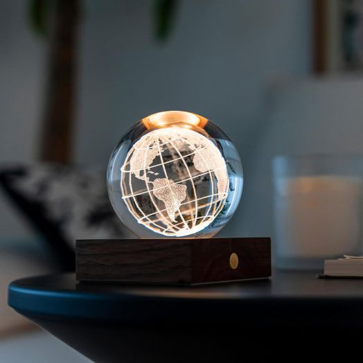 Нощна лампа Gingko Amber Crystal Light World Globe има светещ стъклен глобус върху дървена основа, допълнен от свещ и размит фон за топла и уютна атмосфера.-2