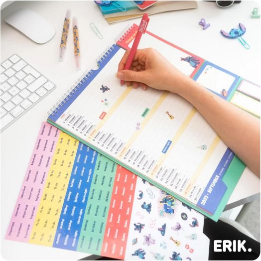 Човек пише в цветна, подвързана със спирала Планер-пад Grupo Erik Stitch за 16 месеца (септември 2025 - декември 2026), заобиколен от химикалки, стикери и клавиатура -перфектен креативен органайзер с илюстрации на Стич.-4