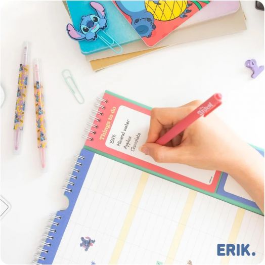 Ръка пише списък със задачи с розова химикалка в цветен тефтер със спирала заедно с декоративни химикалки, щипки, бележници и Планер-пад Grupo Erik Stitch за 16 месеца - септември 2025 / декември 2026 година; логото на ERIK е долу вдясно.-3