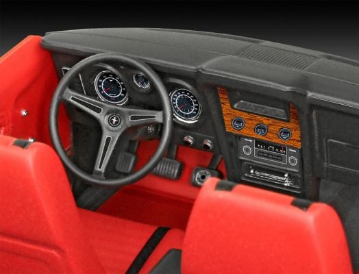 Изглед отблизо на интериора на класически автомобил с черен волан, аналогови измервателни уреди, дървено табло и червени седалки - точно като на емблематичния Ford Mustang Mach 1 от сглобяем модел Revell - Ford Mustang Mach 1.-5