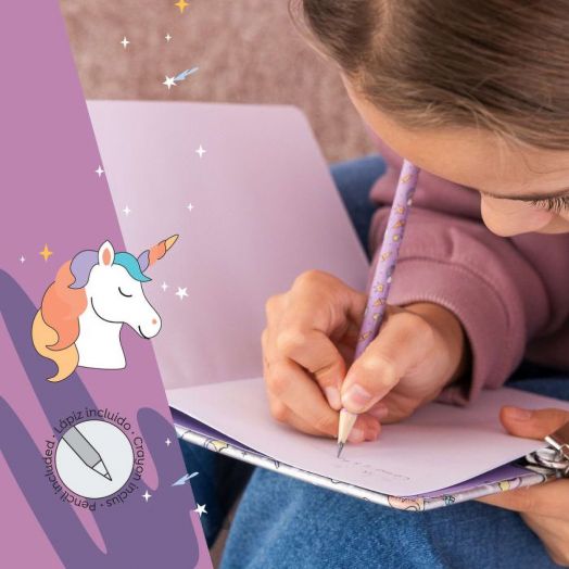 Дете с лилав суитчър пише в тетрадка с пастелен молив. Изображението показва иконата за холограмен еднорог и острилка в лявата част на Тефтер Miquelrius Back2Fun Holographic Unicorn таен дневник.-5