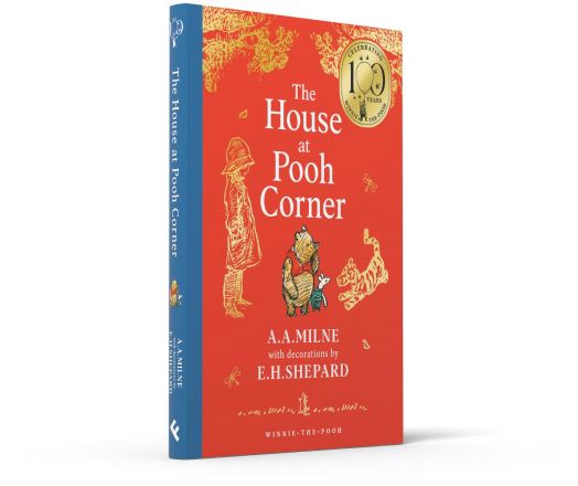 Червена книга, озаглавена "Къщата в кътчето на Мечо Пух", има корица с изображение на дете с Мечо Пух от Е. Х. Шепърд и златен печат за 100-годишнината в горния десен ъгъл.-3