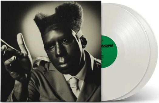 Tyler The Creator - CHROMAKOPIA (2 VINYL) е хип-хоп албум с черно-бяла обложка, на която е изобразен стилизиран портрет на човек в костюм и с плоска блуза. До обложката частично се виждат две непрозрачни бели винилови плочи.