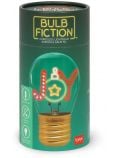 Лампа крушка Legami Bulb Fiction - Joy е акумулаторна настолна лампа с надпис "JOY" и звезда в крушката, изобразени с цветни букви в неонов стил. На зелената цилиндрична опаковка са изобразени икони на продукта, USB зареждане и логото на Legami.